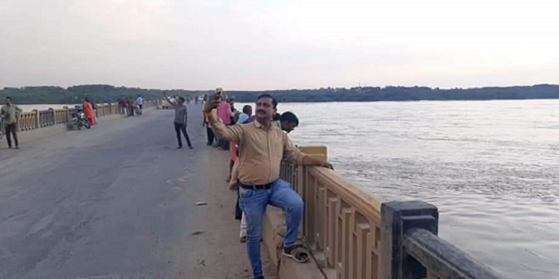 इटावा में चंबल नदी के पुल पर बाढ़ के नजारे के साथ सेल्फी लेने पहुंच रहे राहगीर ।
