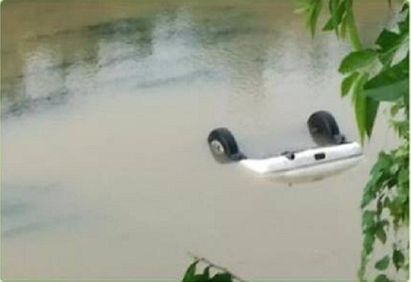 कार को पानी से निकालने का प्रयास किया जा रहा है। 